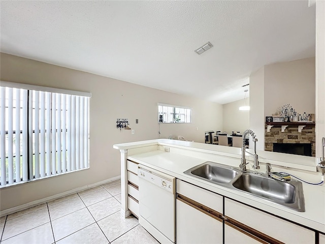 kitchen featuring a fireplace, decorative light fixtures, dishwasher, sink, and white cabinets