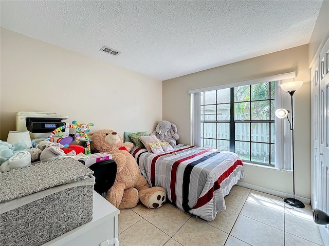 bedroom featuring a textured ceiling and light tile patterned flooring