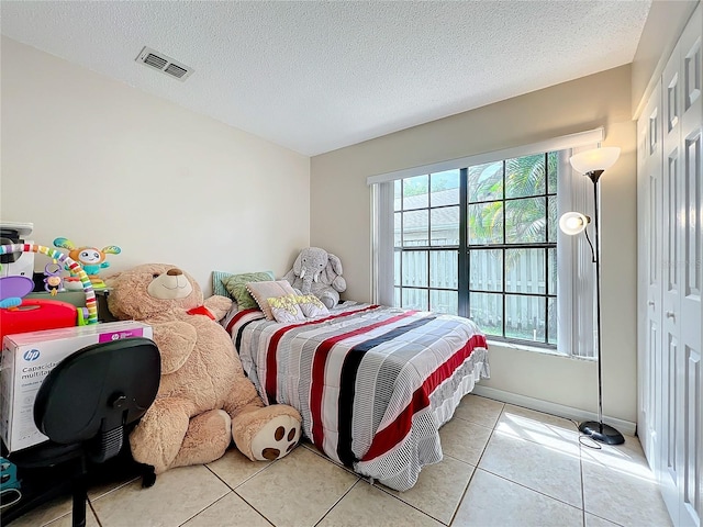 tiled bedroom with a textured ceiling