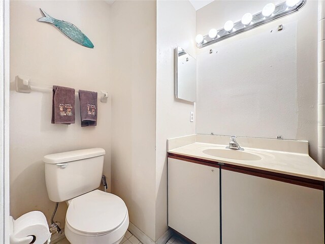 bathroom with tile patterned flooring, vanity, and toilet