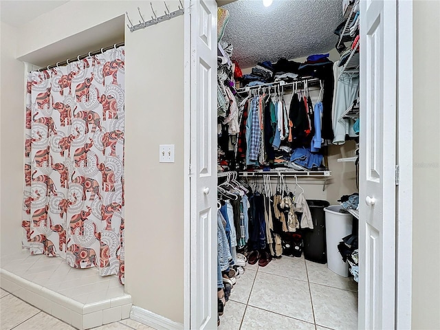 walk in closet with light tile patterned flooring