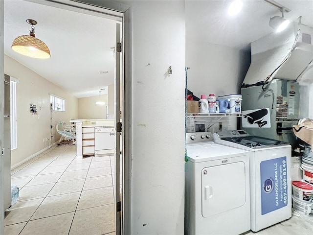 laundry room featuring washing machine and dryer, light tile patterned floors, and heating unit