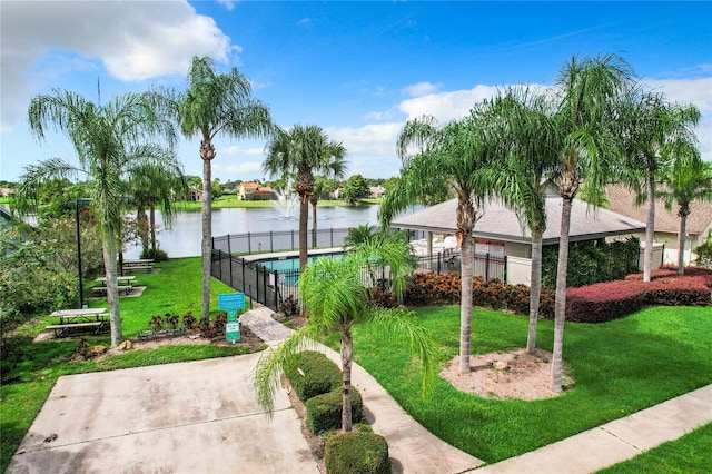 view of home's community featuring a water view, a lawn, and a pool