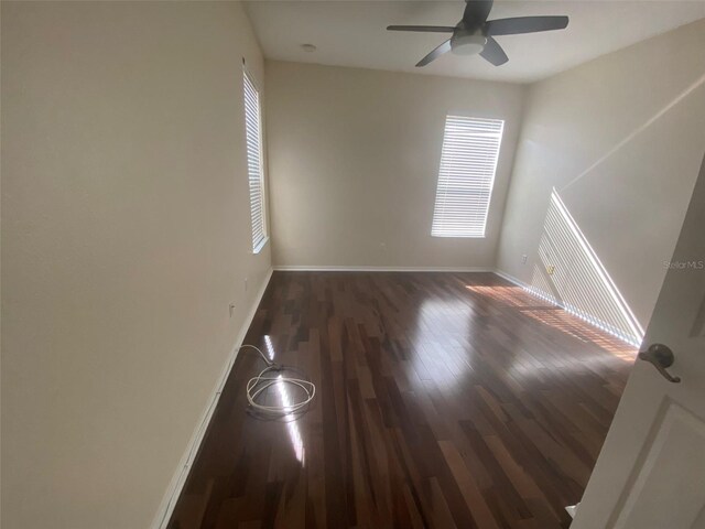 empty room featuring dark hardwood / wood-style flooring and ceiling fan