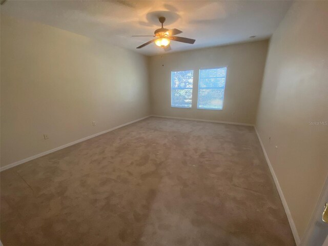 unfurnished room featuring ceiling fan and carpet floors