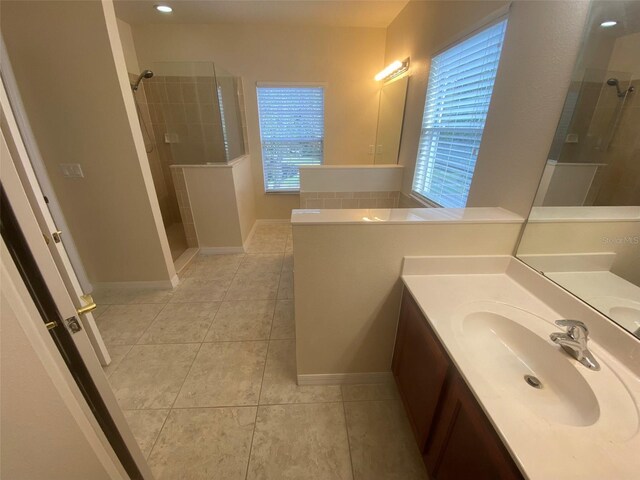 bathroom featuring tiled shower, plenty of natural light, and tile patterned floors