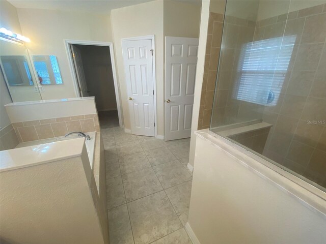 bathroom with separate shower and tub and tile patterned floors