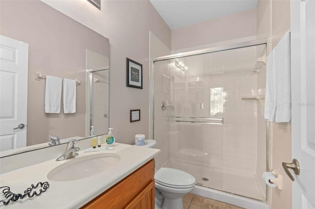 bathroom with a shower with shower door, tile patterned flooring, toilet, and vanity