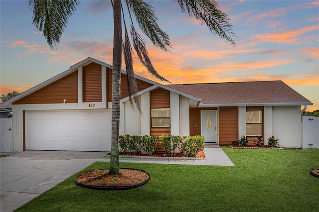 single story home featuring a garage and a yard