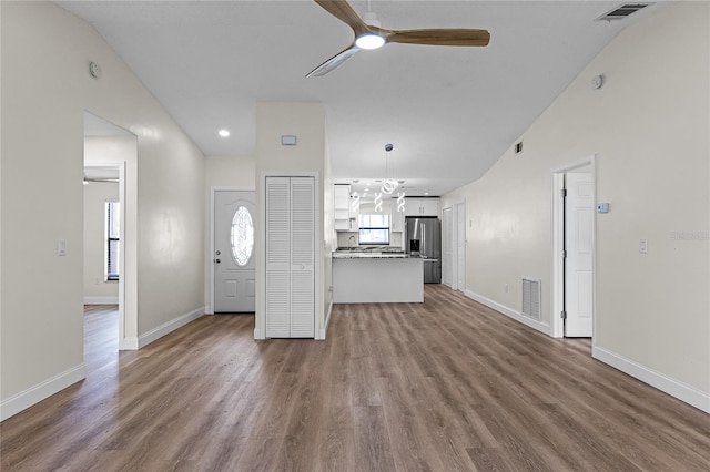 unfurnished living room featuring lofted ceiling, wood-type flooring, and ceiling fan