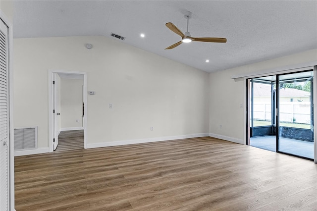 empty room with vaulted ceiling, a textured ceiling, light hardwood / wood-style flooring, and ceiling fan