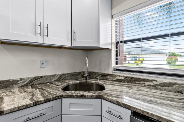 kitchen with a wealth of natural light, sink, and white cabinetry