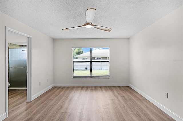 empty room featuring a textured ceiling, light hardwood / wood-style flooring, and ceiling fan