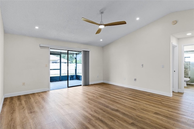 empty room with a textured ceiling, light hardwood / wood-style flooring, ceiling fan, and lofted ceiling