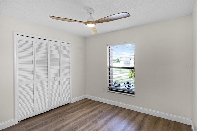 unfurnished bedroom featuring a textured ceiling, wood-type flooring, ceiling fan, and a closet