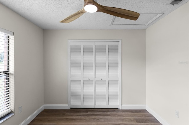 unfurnished bedroom featuring a textured ceiling, hardwood / wood-style floors, ceiling fan, and a closet