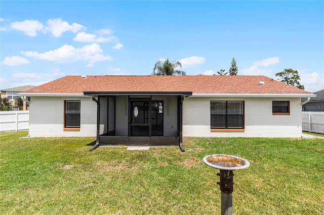 back of property with a sunroom and a yard