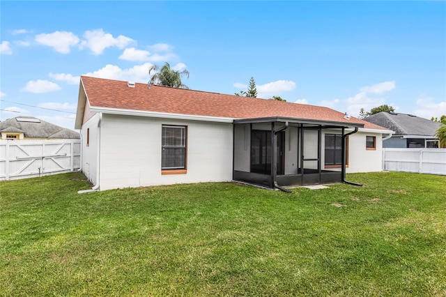 back of property with a sunroom and a lawn