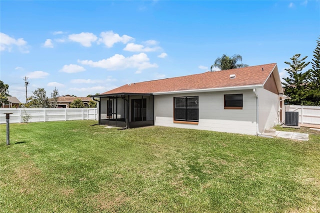 back of property featuring a yard, a sunroom, and central AC