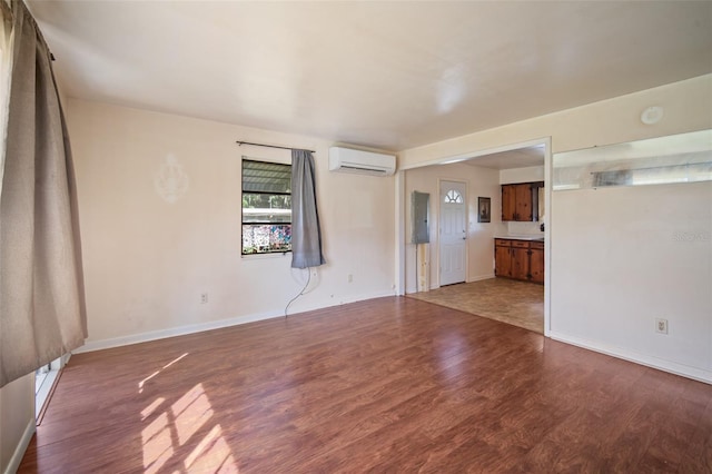 unfurnished living room with dark wood-type flooring, a wall unit AC, and electric panel