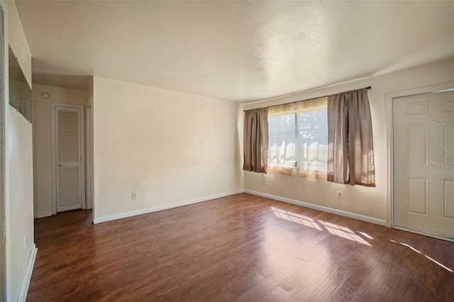 spare room with dark hardwood / wood-style floors