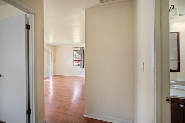 hallway featuring wood-type flooring and sink