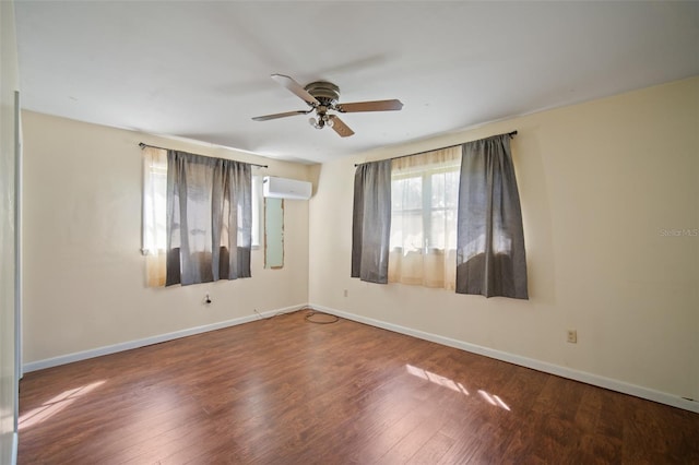 spare room with dark wood-type flooring, ceiling fan, and a wall unit AC