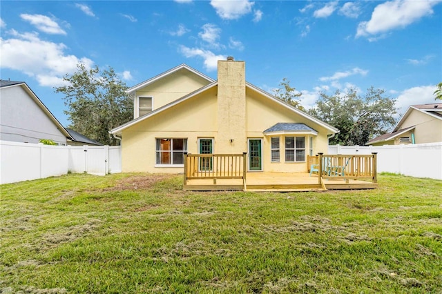 rear view of property with a deck, a yard, and a fenced backyard