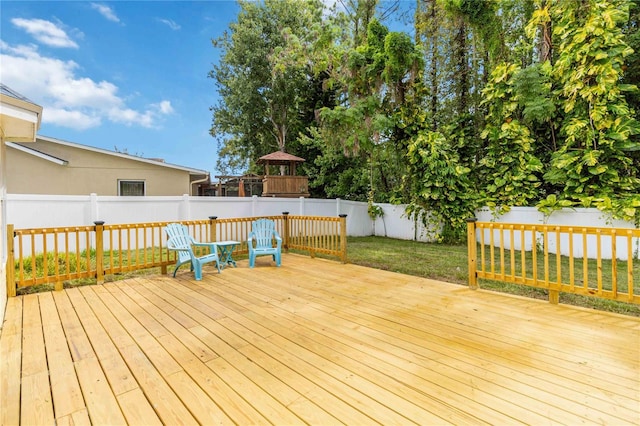 wooden deck featuring a fenced backyard and a lawn