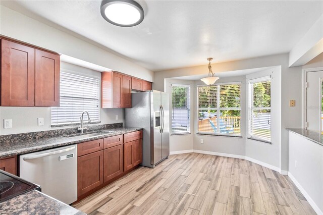 kitchen featuring light wood-style floors, plenty of natural light, appliances with stainless steel finishes, and a sink