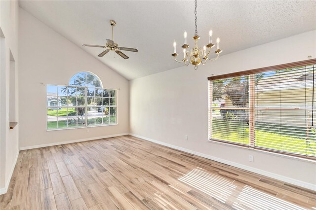 unfurnished room featuring baseboards, vaulted ceiling, light wood-style flooring, and a textured ceiling