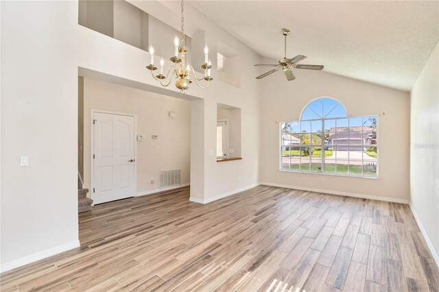 spare room featuring ceiling fan with notable chandelier, wood finished floors, visible vents, and baseboards