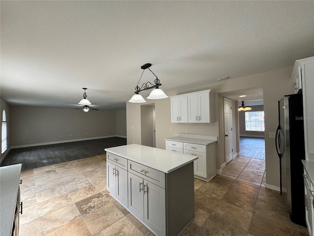 kitchen with white cabinets, stainless steel fridge, decorative light fixtures, and ceiling fan