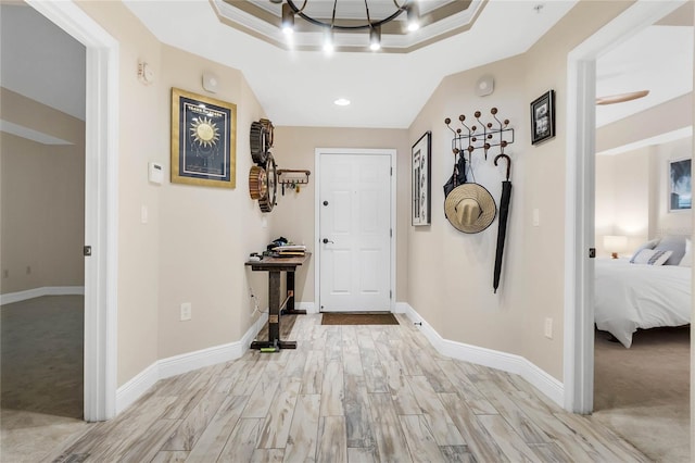 carpeted entryway with a tray ceiling