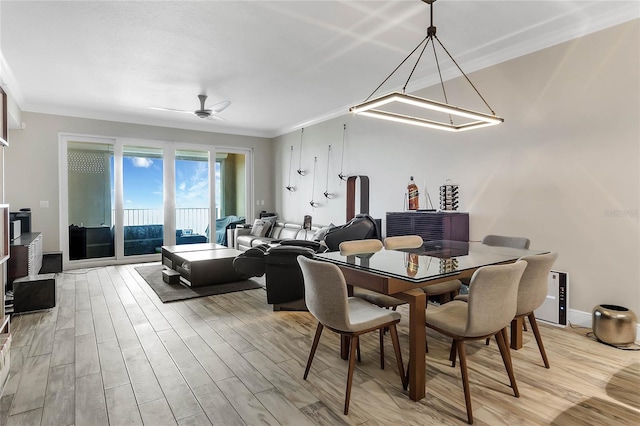 dining space featuring light wood-type flooring and ornamental molding