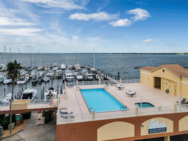 view of pool featuring a water view and a patio area