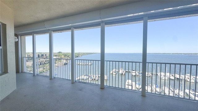 unfurnished sunroom featuring a water view