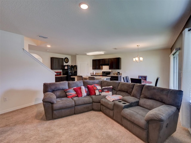 carpeted living room with a chandelier