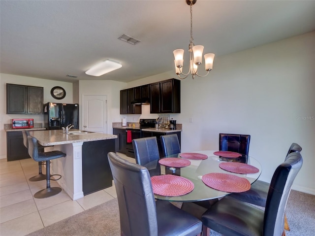 dining area featuring light tile patterned floors, a chandelier, and sink