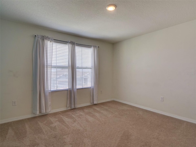 unfurnished room with a textured ceiling and carpet floors