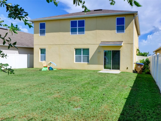 rear view of property featuring a yard