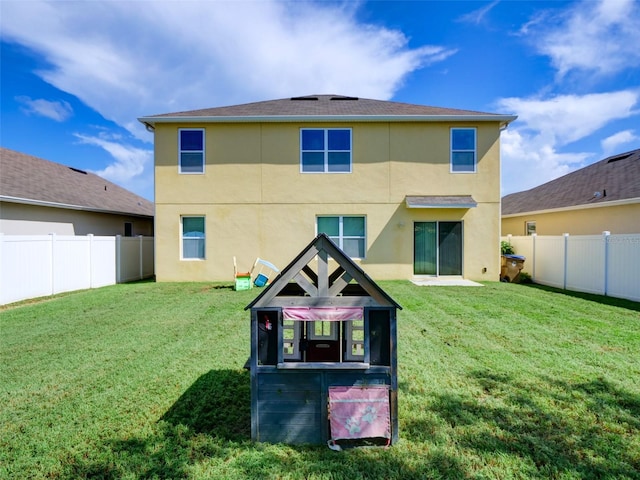 rear view of house featuring a lawn