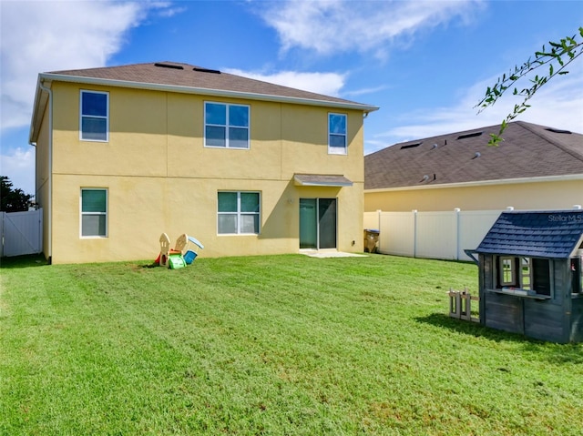 rear view of property with an outdoor structure and a lawn