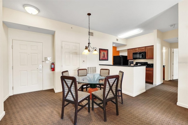 dining area featuring an inviting chandelier and dark colored carpet