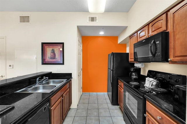 kitchen featuring light tile patterned floors, sink, dark stone counters, and black appliances