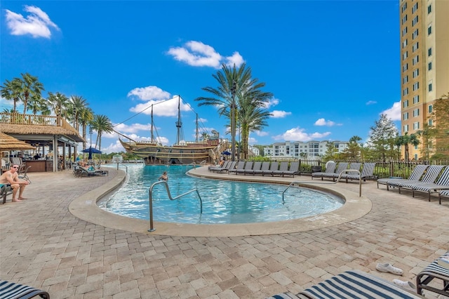 pool with fence and a patio area