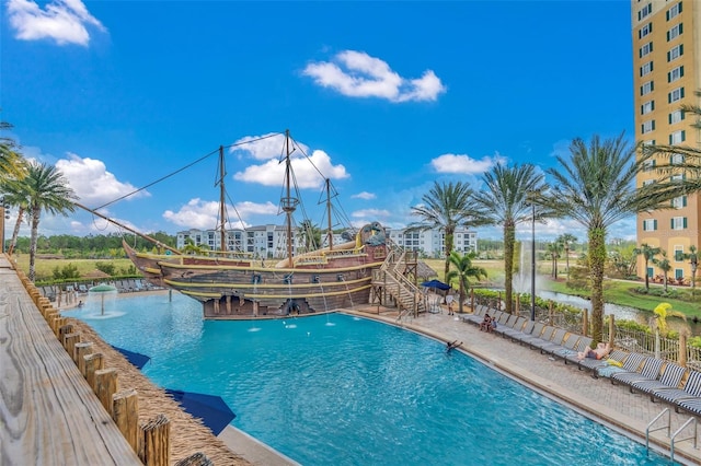 view of pool with pool water feature and a water view