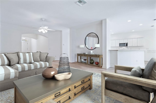 living room featuring ceiling fan and light hardwood / wood-style floors