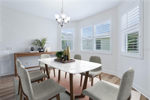 dining space with an inviting chandelier and hardwood / wood-style flooring