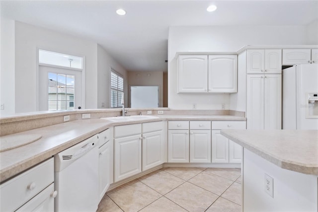 kitchen with white appliances, white cabinetry, and light tile patterned flooring